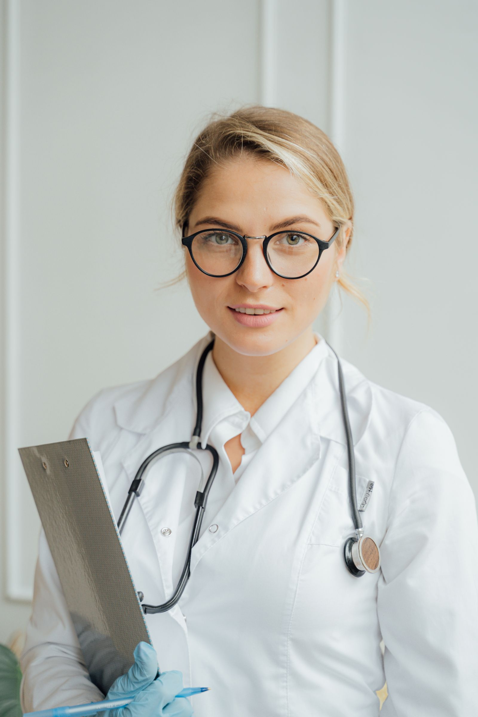 Healthcare professional in a white coat holding a clipboard